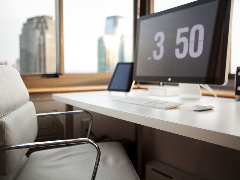 A minimal desk setup with a monitor and clock
