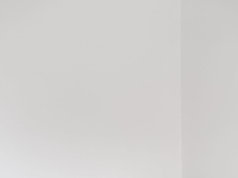 A compact printer on a desk against a plain white wall