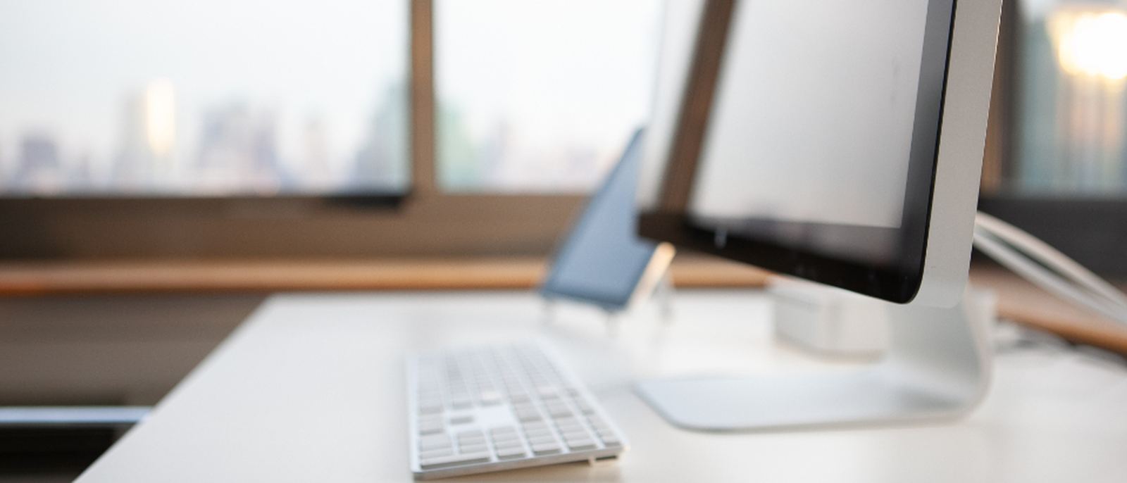 A clean office desk with monitors and daylight