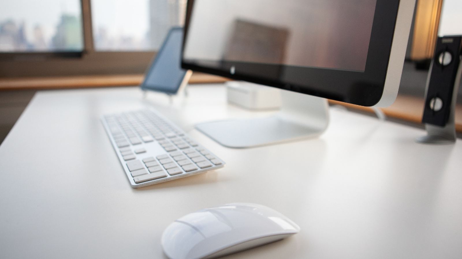 A desk with a keyboard and mouse on a light surface