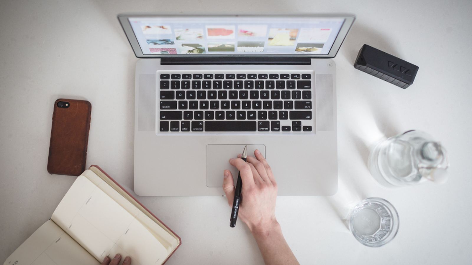 An overhead view of a desk with a laptop and notes