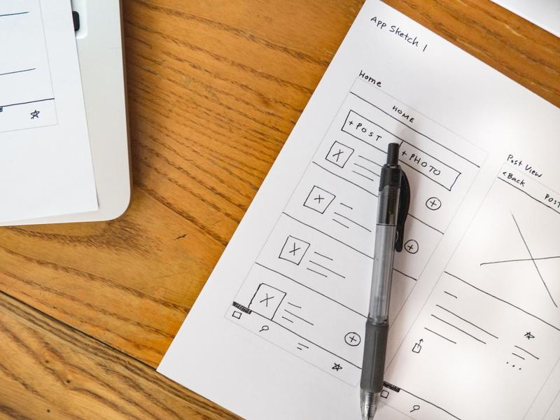 A notebook, pen and mouse arranged on a desk